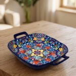 Square ceramic 6-inch Marrakesh decorative bowl with vibrant floral mandala pattern and side handles sitting on a wooden table.