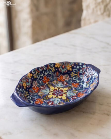 9.5-inch decorative Marrakech oval ceramic serving bowl with intricate blue, orange, and yellow hand-painted floral patterns resting on a marble countertop