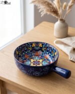 6-inch vibrant blue decorative Marrakesh ceramic bowl with colorful mosaic patterns and side handle on a wooden table.