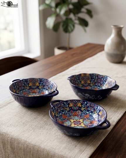 Three hand-painted decorative Marrakech ceramic bowls with intricate bohemian patterns and handles arranged on a dining table runner.