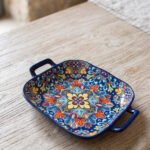 Vibrant blue 9.5-inch decorative Marrakech ceramic serving bowl with handles featuring a colorful mandala pattern on a rustic wooden table.