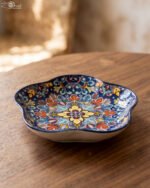 Decorative Marrakesh serving dish with a colorful ceramic mandala pattern and wavy edges on a wooden table