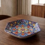 Decorative Marrakesh ceramic serving dish with colorful Moroccan mosaic pattern resting on a wooden dining table.