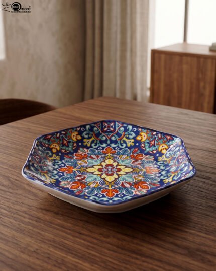 Decorative Marrakesh ceramic serving dish with colorful Moroccan mosaic pattern resting on a wooden dining table.