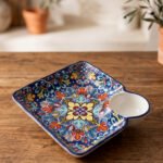 Square hand-painted Moroccan ceramic serving dish with colorful Marrakech floral pattern and built-in dip bowl on a wooden table.