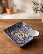 Square hand-painted Moroccan ceramic serving dish with colorful Marrakech floral pattern and built-in dip bowl on a wooden table.