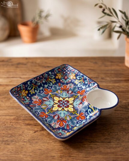 Square hand-painted Moroccan ceramic serving dish with colorful Marrakech floral pattern and built-in dip bowl on a wooden table.