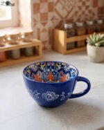 Royal blue handcrafted Marrakech ceramic mug with intricate floral interior pattern sitting on a kitchen counter