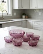 7-piece grey ribbed glass fruit set featuring one large serving bowl and six small bowls with elegant gold rims, displayed on a kitchen counter.