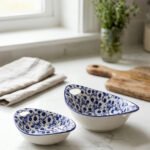 Two decorative Marakesh blue and white floral ceramic serving dishes with handles resting on a kitchen countertop.