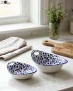 Two decorative Marakesh blue and white floral ceramic serving dishes with handles resting on a kitchen countertop.