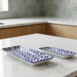 Two rectangular blue and white decorative Marrakesh serving dishes in 8-inch and 10-inch sizes displayed on a marble countertop.