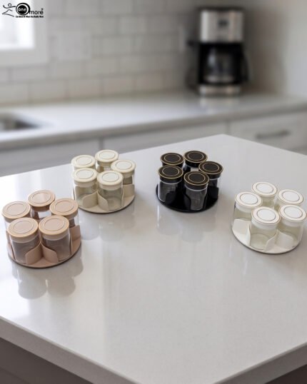 Four modern 6-piece revolving glass spice jar sets with gold trim lids displayed on a white kitchen countertop in beige, cream, black, and white colors.