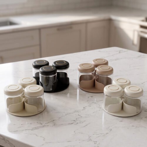 Four modern glass spice jar sets in black, tan, cream, and off-white with gold lid rings arranged on a marble kitchen countertop.