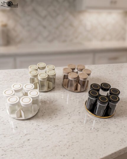 Modern rotating spice rack organizer set with 6 clear glass jars and gold-accented lids on a granite kitchen countertop.