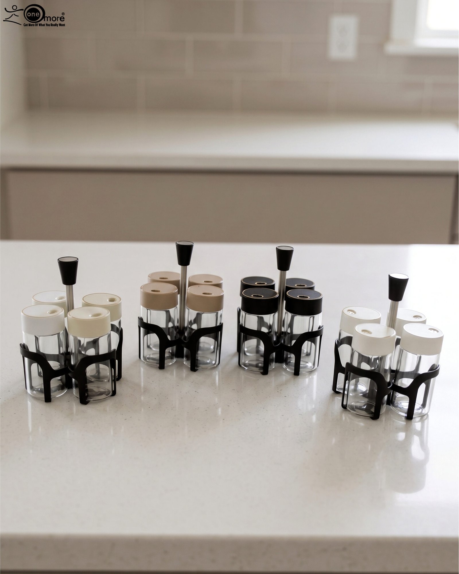 1 Four-piece clear glass spice jar set with lid options sitting in a black metal holder on a kitchen countertop.