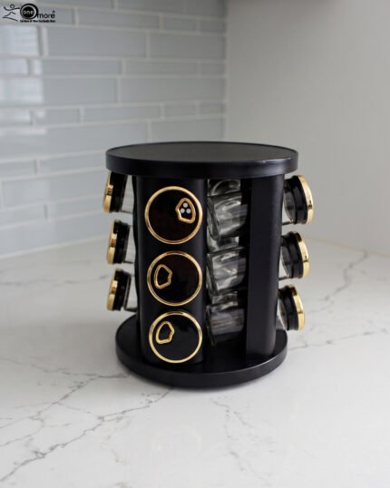 Modern 12-piece rotating black and gold spice rack organizer with glass jars on a white marble kitchen countertop