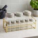 9-piece clear glass spice jar set with grey lids and a gold wire countertop rack