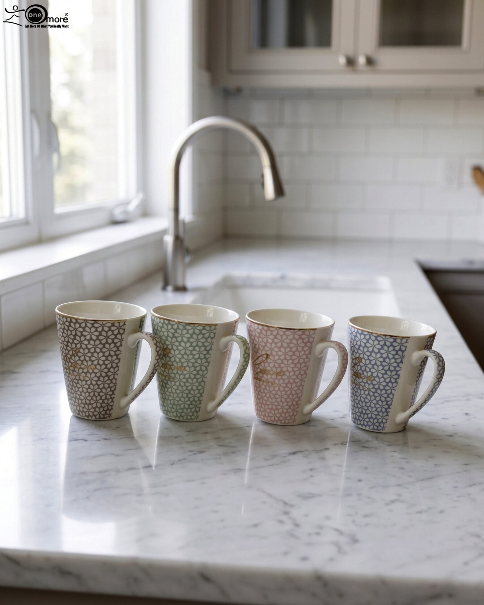 1 Four ceramic coffee mugs in beige, mint green, blush pink, and light blue with floral geometric patterns displayed on a marble countertop.