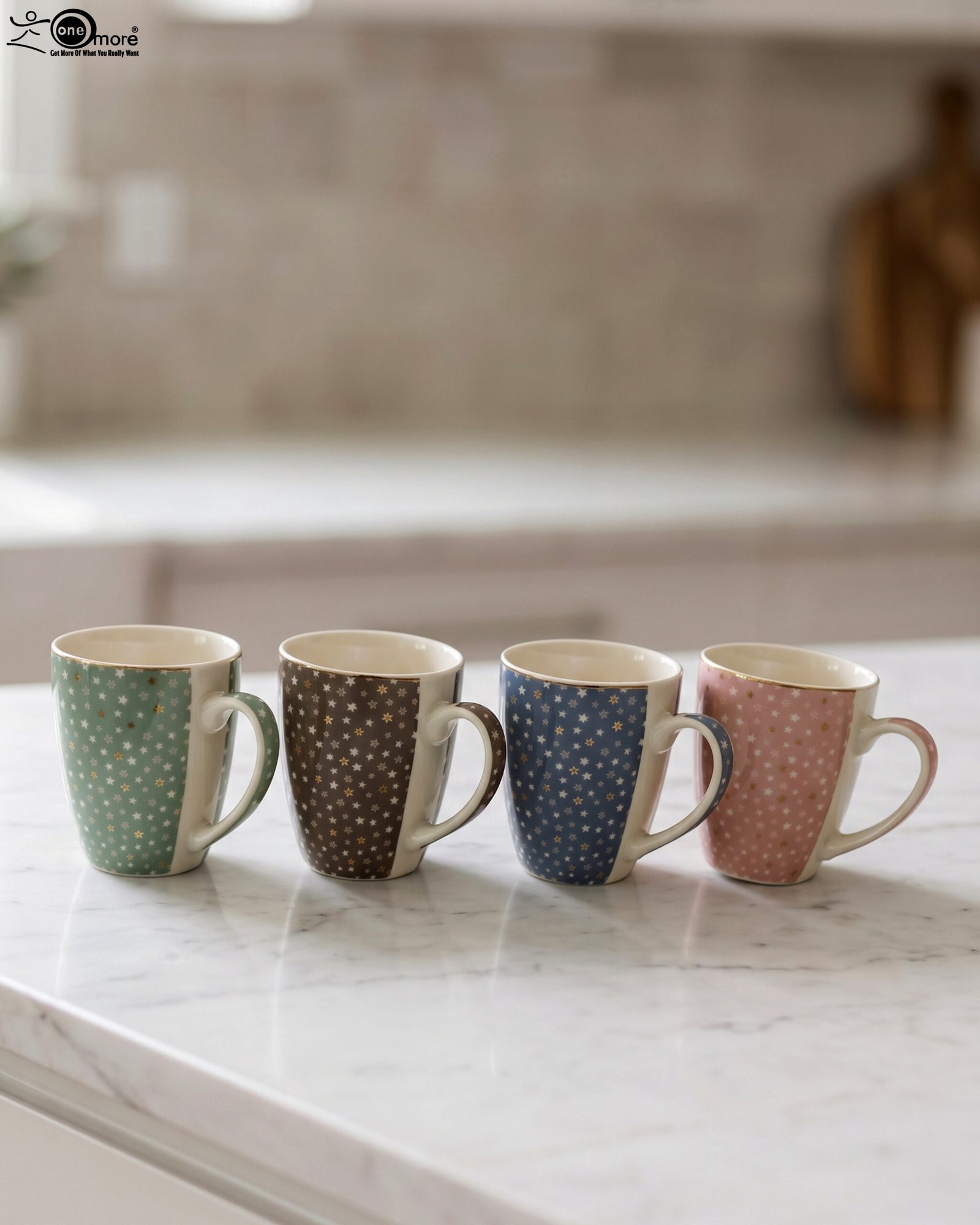 1 4-piece ceramic coffee mug set with gold star patterns in sage green, brown, navy blue, and blush pink on a white marble countertop.