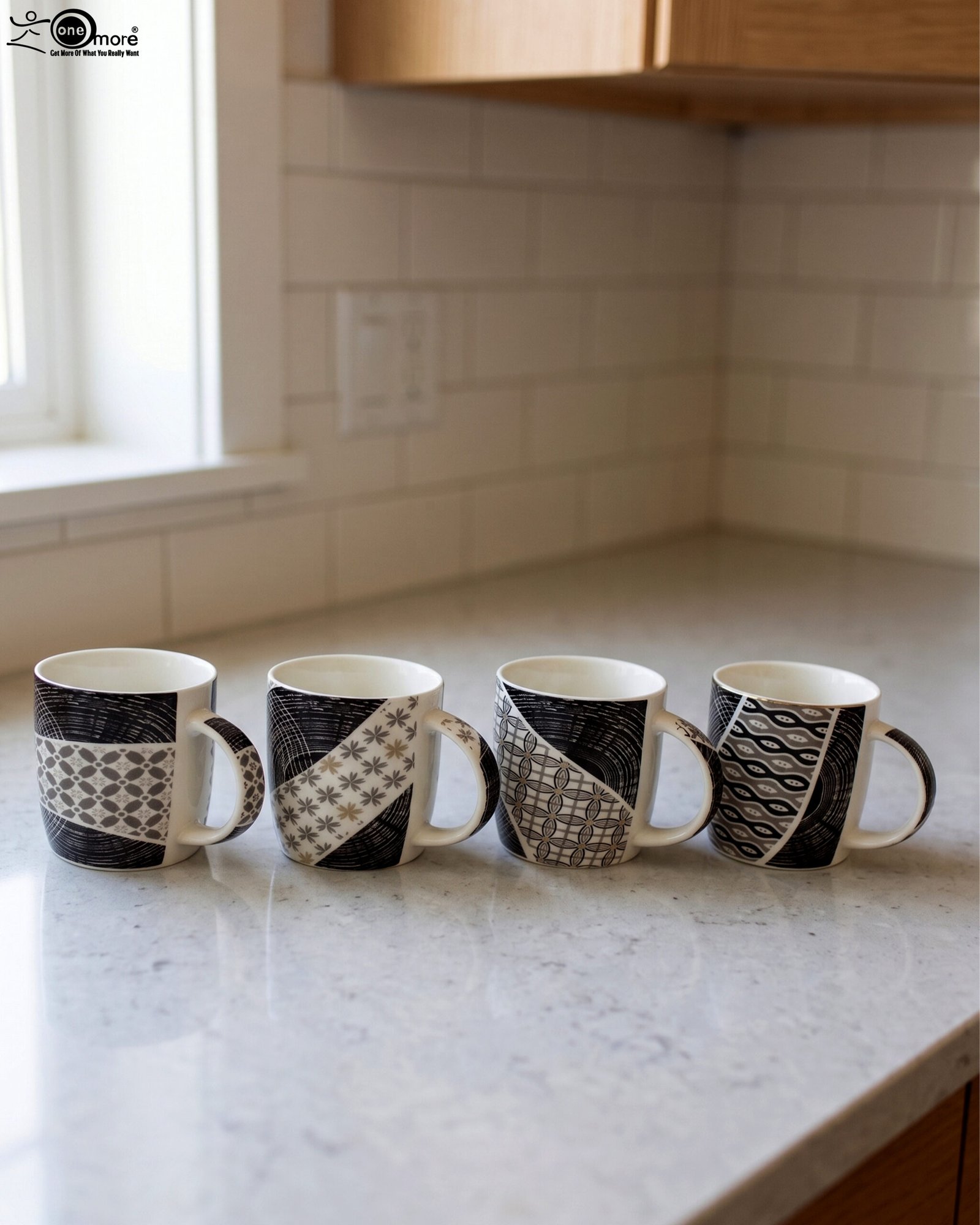 1 Set of 4 modern ceramic coffee mugs with distinct black, white, and grey geometric patterns displayed on a kitchen countertop.