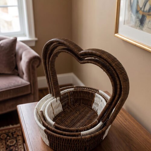 Nested set of three brown and white handwoven rattan trays featuring tall heart-shaped handles on a wooden table