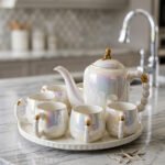 Luxury iridescent ceramic tea set with 6 cups, 1 kettle, and a rotating tray displayed on a marble kitchen counter