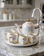 Luxury iridescent ceramic tea set with 6 cups, 1 kettle, and a rotating tray displayed on a marble kitchen counter