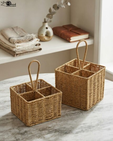 Two handwoven rattan spoon holders with four divided compartments and loop handles sitting on a marble table.