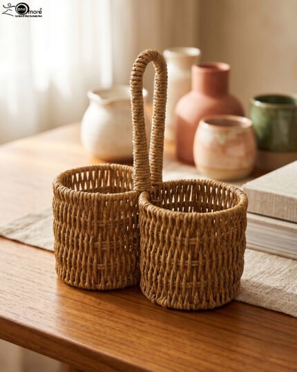 Handmade woven rattan spoon holder with two round caddy compartments and a high center handle on a wooden dining table.