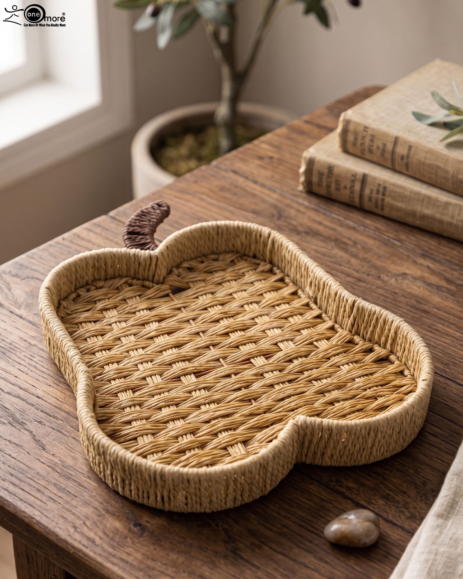 1 Handwoven light brown rattan fruit dish shaped like an apple resting on a rustic wooden table