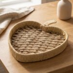 Apple-shaped handwoven rattan fruit tray sitting on a light wooden table