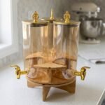 3-piece amber shaded glass beverage dispenser set with gold spigots on a wooden stand