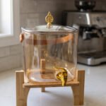 6.5L amber shaded glass beverage dispenser with gold spigot on a wooden stand