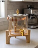 6.5L amber shaded glass beverage dispenser with gold spigot on a wooden stand