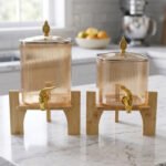 Ribbed amber glass beverage dispenser with gold tap and pineapple lid finial on a wooden stand