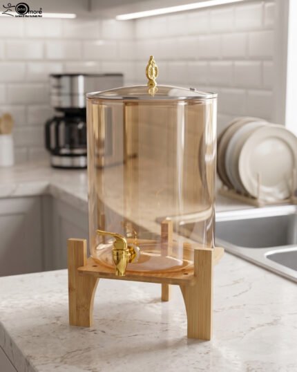 Amber glass drink dispenser with gold spigot resting on a natural wooden stand on a kitchen counter.