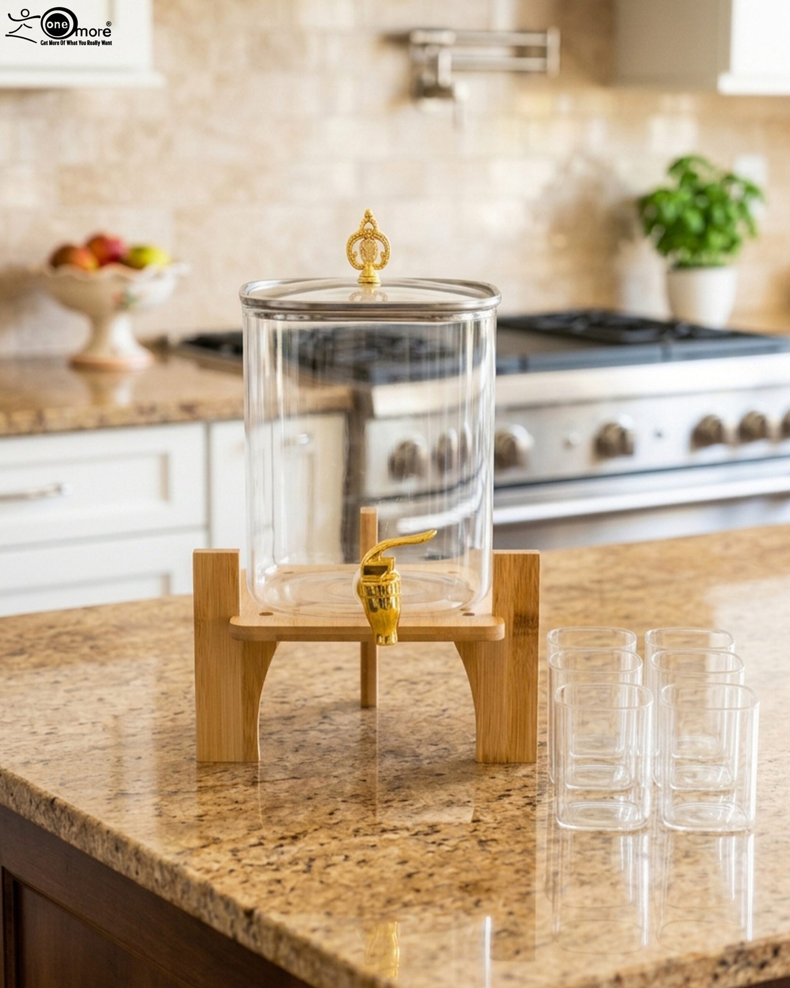 1 4.2L clear glass beverage dispenser with a gold spigot, gold lid handle, natural wooden stand, and 4 drinking glasses on a kitchen island.