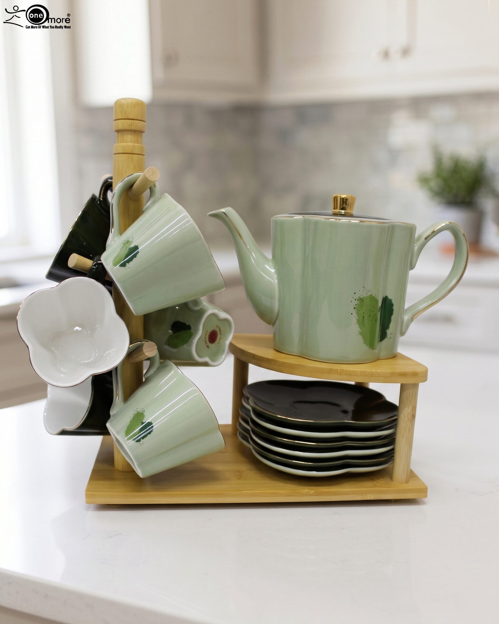 1 Green and black ceramic tea set with 6 cups, kettle, saucers, and a wooden display stand on a kitchen counter
