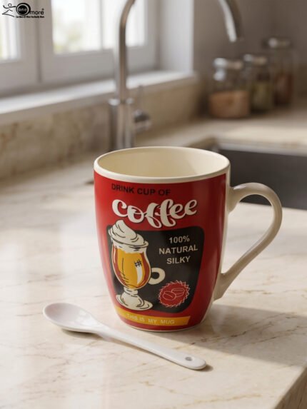 Red ceramic coffee mug with vintage coffee graphic print and matching white ceramic spoon on a kitchen counter