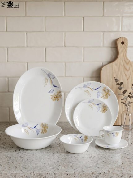 Elegant 32-piece white floral printed dinner set displayed on a marble countertop with plates, bowls, cups, and a platter