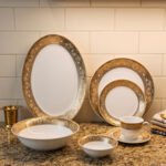 32-piece white porcelain dinner set with embossed gold trim including plates, bowls, cups, and a serving platter