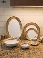 32-piece white porcelain dinner set with embossed gold trim including plates, bowls, cups, and a serving platter