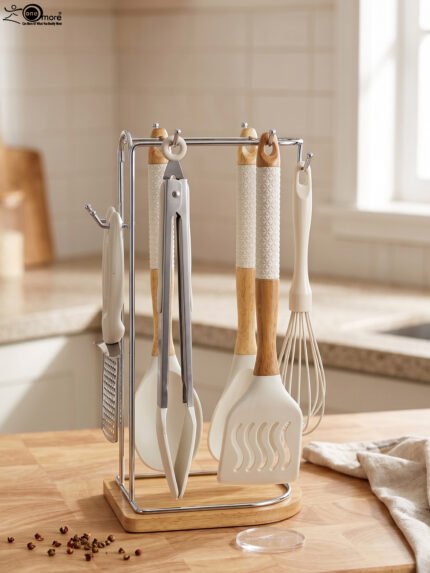 8 piece white silicone kitchen utensil set hanging on a stainless steel stand with wooden handles on a wooden countertop