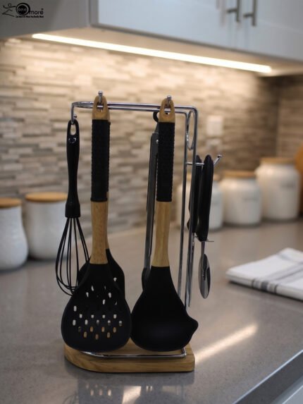 8 piece black silicone kitchen utensil set with wooden handles hanging on a chrome stand