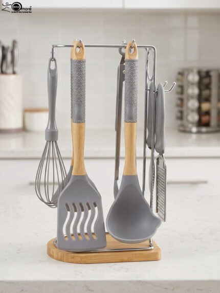8 pcs grey silicone cooking utensils set with wooden handles hanging on a stainless steel stand with wooden base
