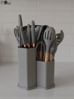 Grey 19-piece silicone kitchen utensil and knife set with wooden handles in a matching grey dual-compartment storage block.