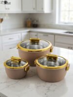 3-piece beige insulated hotpot set with glass lids and gold rims on a white marble countertop