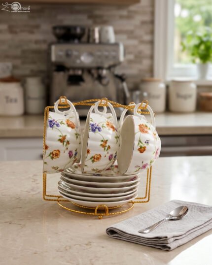 Luxury ceramic tea set with 6 floral cups, matching saucers, and a golden stand on a kitchen counter.
