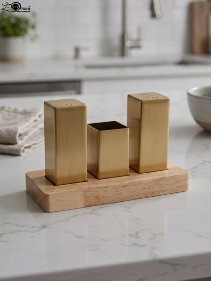 Modern brushed gold stainless steel salt and pepper shaker set with toothpick holder in a wooden base on a kitchen counter